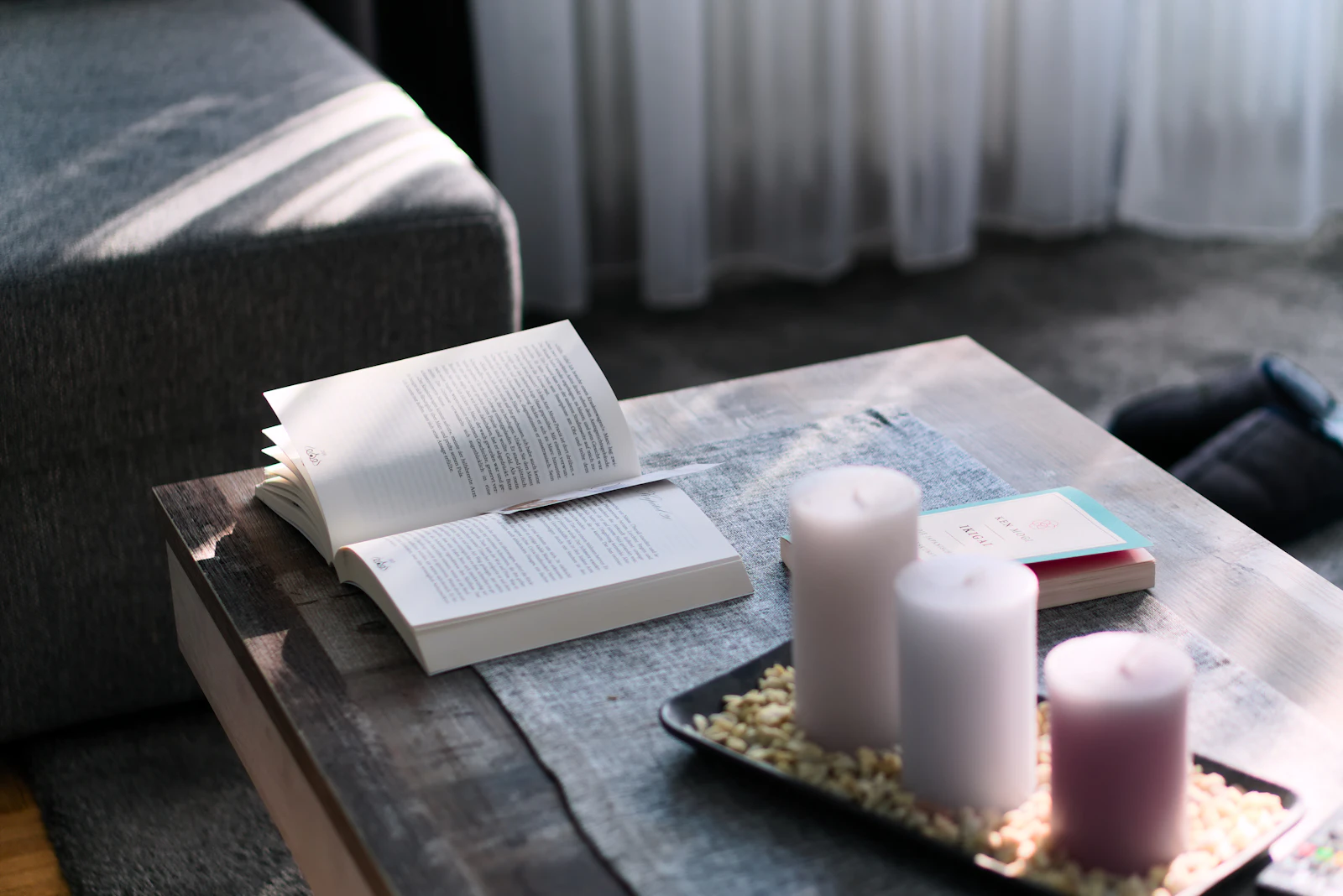 Open book and lit candles styled on a coffee table