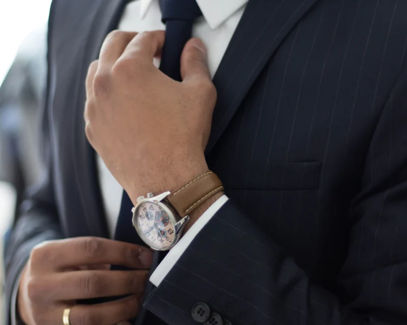 Close-up of a man adjusting the knot of his necktie